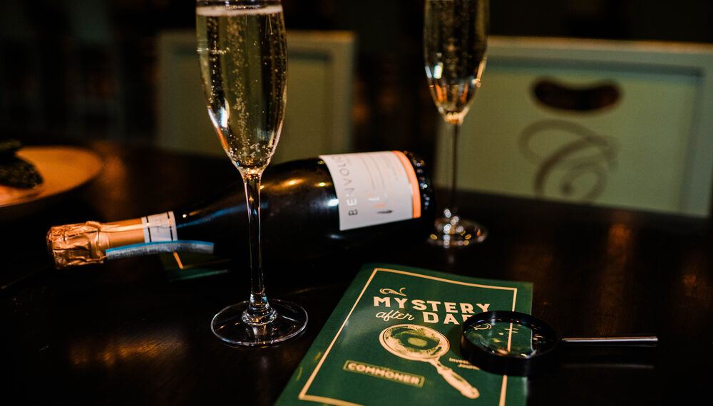 2 glasses of sparkling wine and a mystery after dark booklet